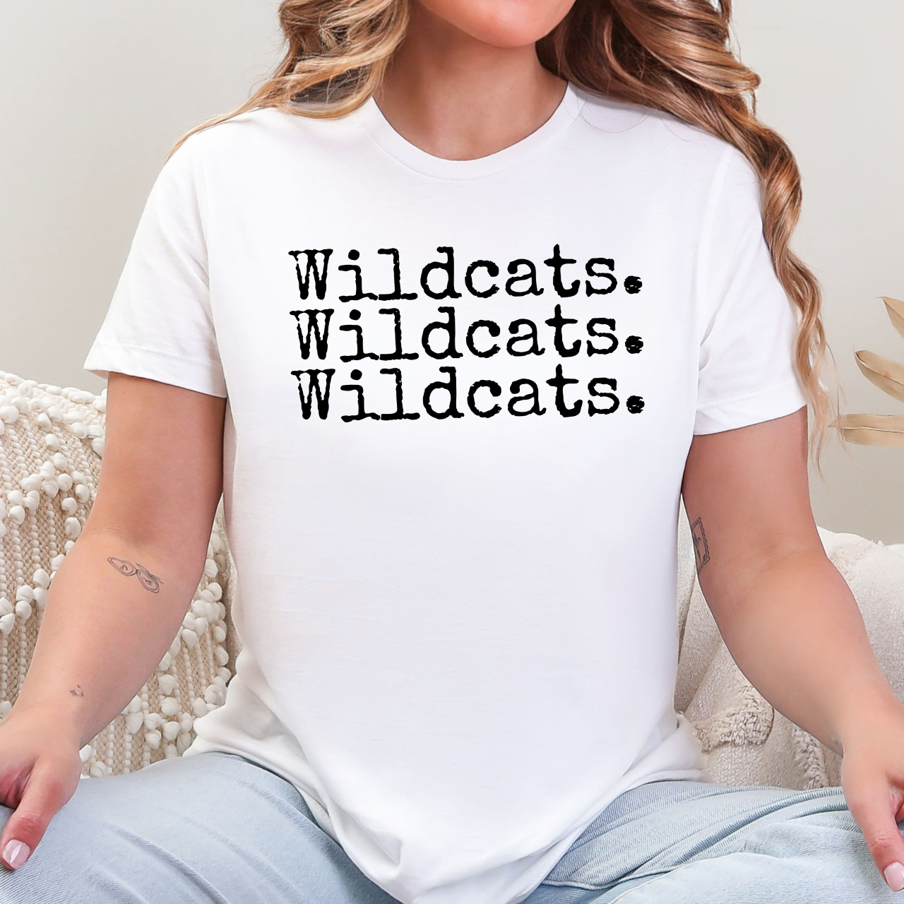Person wearing a white t-shirt with 'Wildcats. Wildcats. Wildcats.' text.