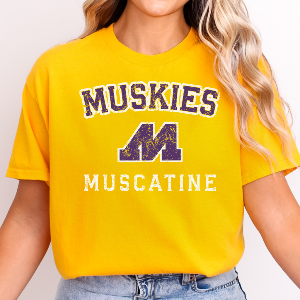 Person wearing a yellow t-shirt with 'Muskies Muscatine' text and logo.