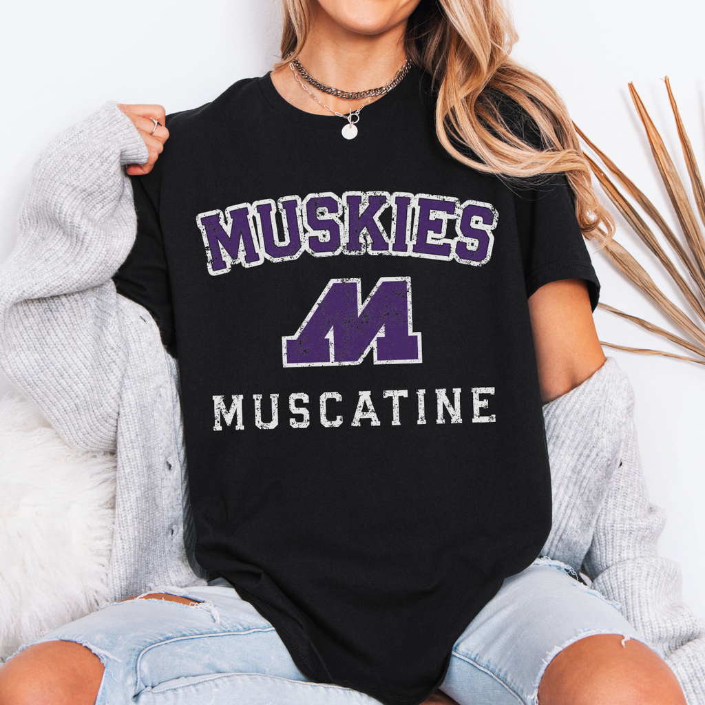 Person wearing a black t-shirt with 'Muskies Muscatine' design