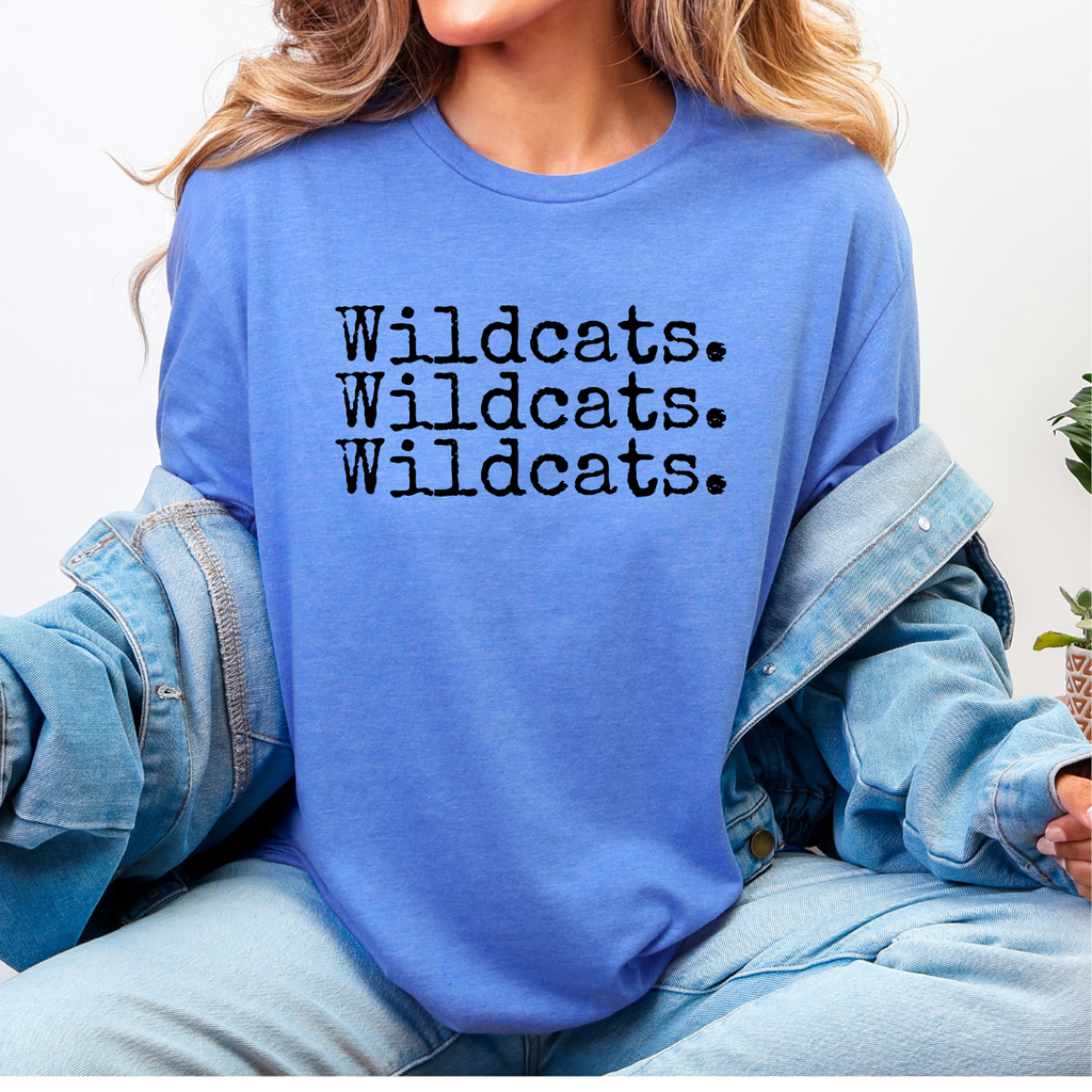 Person wearing a blue tee with 'Wildcats. Wildcats. Wildcats.' text.