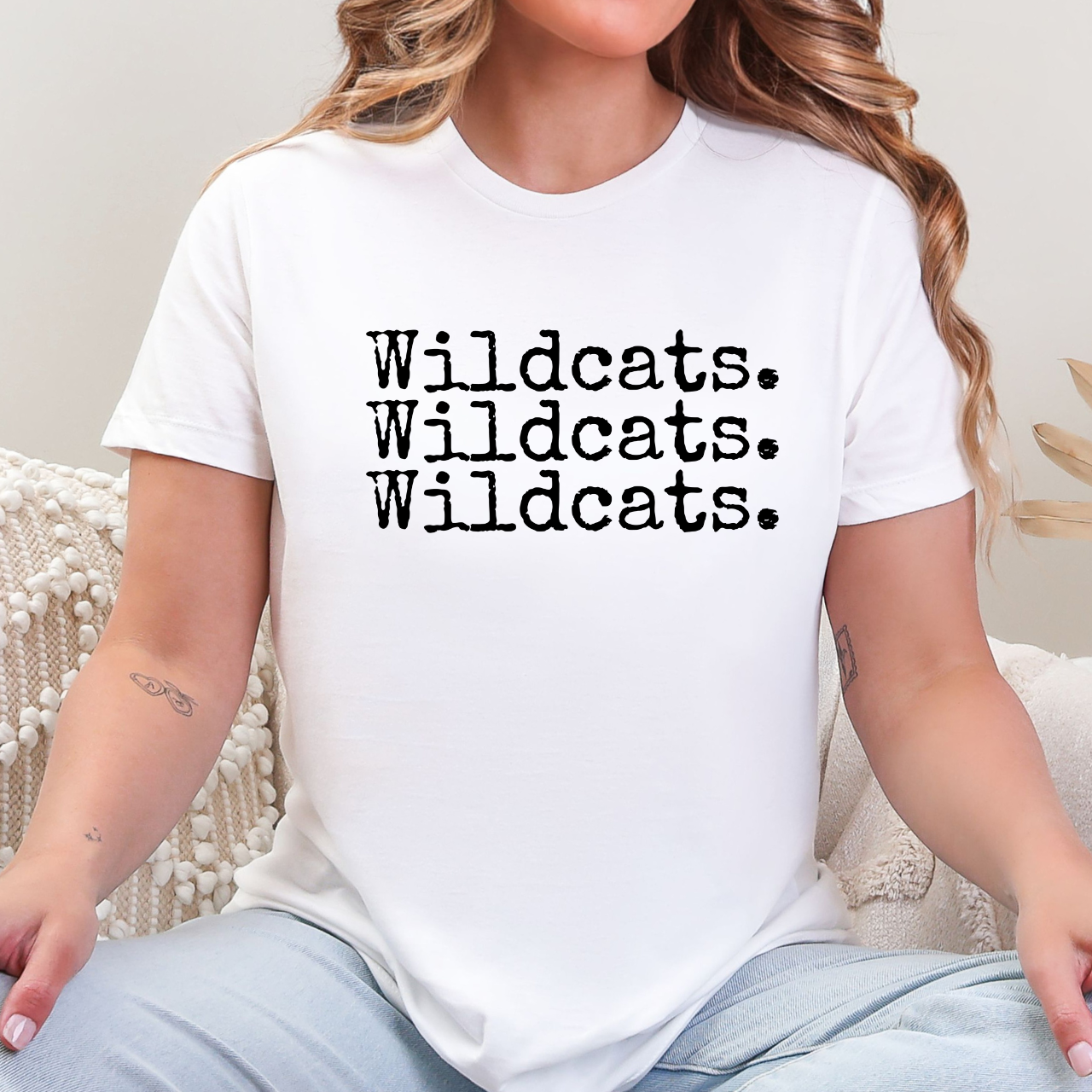 Person wearing a white t-shirt with 'Wildcats. Wildcats. Wildcats.' text.